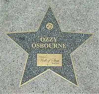 Étoile grise insérée sur un trottoir avec marqué dessus 'Ozzy Osbourne'.