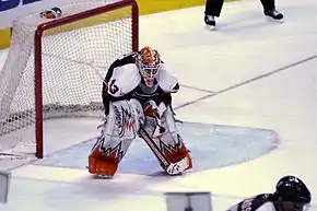 Photographie couleur d’un gardien de but de hockey sur glace penché en avant.