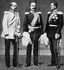 Les trois hommes sont côte à côte en grand-uniforme avec épaulettes. Bismarck et von Roon portent la moustache, mais pas von Moltke.