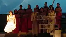 Image floue d'une femme habillée d'une robe chantant devant un chœur