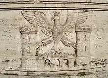 Le blason de la ville, représentant un aigle couronné tenant dans ses serres les deux tours de la Rocca Pia, sculpté dans le travertin d'une fontaine
