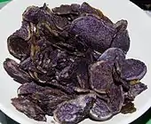 Fort contraste de chips violets sur une assiette blanche.