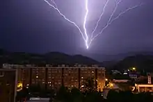 Éclair partant d'une tour de télécommunication jusqu'aux nuages. On peut facilement remarquer que la décharge se fait du sol aux nuages car les ramifications de celui-ci partent toutes de la tour de télécommunication.