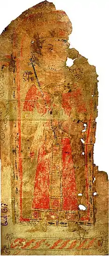 Photographie en couleur d'un manuscrit en partie déchiré représentant un homme habillé de rouge