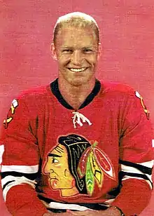 Photographie du joueur avec un maillot de hockey rouge floqué du logo des Black Hawks de Chicago