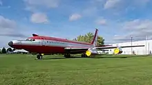 Boeing 720 rouge et blanc, exposé sur une pelouse. Il a été modifié, il est doté d'un nez très long et quelques protubérences inhabituelles sont visibles sur le fuselage.