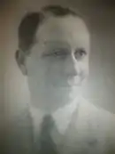 Portrait en buste d'un jeune homme en cravate et souriant.