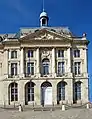 Palais de la Bourse à Bordeaux (1742-1749), avec des éléments caractéristiques du style rocaille : mascarons, ferronnerie à volutes, fenêtres en arc surbaissé avec agrafe.