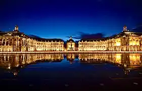 Vue de la place de la Bourse de Bordeaux qui se reflète sur le miroir d'eau, de nuit.