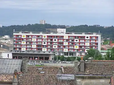 Photographie d'un bâtiment rouge et blanc de 6 étages, devant la Garonne.