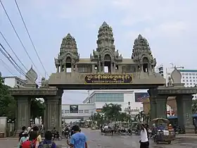 le poste consiste en une porte en béton brute décorée de motif angkorien agrémentée de deux portiques plus petit sur les cotés; l'édifice est surmonté d'un panneau bleu foncé avec en lettres jaunes, l'inscription royaume du Cambodge en khmer et en anglais. À l'arrière plan, des bâtiments blancs laissent deviner le poste thaïlandais d'Aranyaprathet