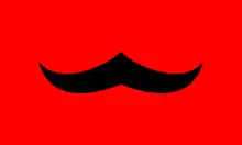Drapeau avec une moustache noire sur fond rouge.