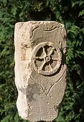 Borne de pierre marquée d'une roue à six rayons.