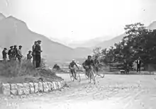 Photographie en noir et blanc montrant des cyclistes dans l'ascension d'un col.