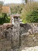 Croix médiévale dans le mur du cimetière.