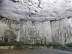 Sous les boulins d'un ancien pigeonnier, les deux ensembles de bas-reliefs de la grotte.