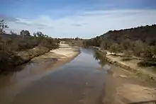 Vue d'un cours d'eau bordé par des arbres.