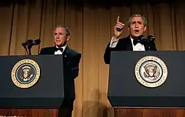 Bush est en retrait alors que son imitateur parle devant un pupitre identique au sien.