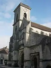 Église de style gothique teinte grise surmontée d'un clocher assez bas ressemblant à une tour