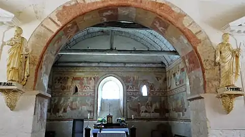 Le chœur vu depuis l'arcade avec les peintures murales sur le mur du chevet et celmles en sous-face de l'arcade.