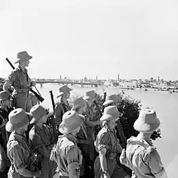 Soldats britanniques en uniformes beiges armés d'un fusil.