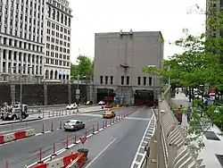 Plusieurs véhicules se dirigeant vers l'entrée d'un tunnel routier.