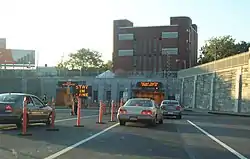 Plusieurs véhicules se dirigeant vers l'entrée d'un tunnel routier.