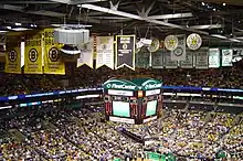 Photo intérieure du TD Garden montrant les spectateurs et les bannières accrochées au plafond de l'édifice.