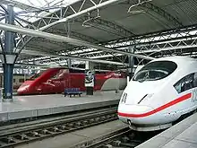 La photo montre deux trains aérodynamiques, sous une marquise rénovée.