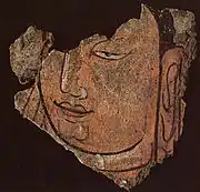 Détail d'une tête du Bouddha 21B. Registre haut du sanctuaire B en bois et enduits peints, vallée de la Keriya. Début du IIIe siècle. Musée provincial, Ürümqi.