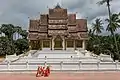 Moines bouddhistes marchant devant le temple Haw Pha Bang