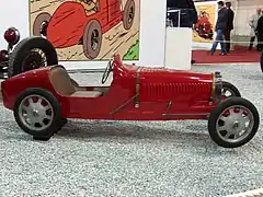 Photographie d'une voiture rouge exposée dans un musée.