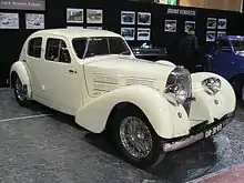 Photo d'une voiture blanche de type berline exposée dans un musée.