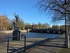 photo d'un quai au bord d'un canal et d'une statue