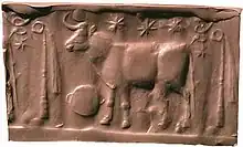 Impression moderne en argile beige d'un sceau-cylindre représentant un taureau sous trois étoiles et entouré de deux symboles.