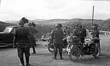 Un groupe de soldats en uniforme, devisant sur une route.