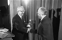 Walter Hallstein on stage, shaking hands while receiving prize.