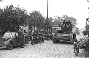 Photographie en noir et blanc de chars soviétiques et motocyclistes allemands.