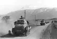 Des véhicules militaires sur une route.