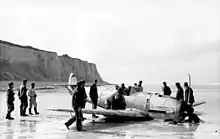 Photographie d'un avion endommagé sur une plage
