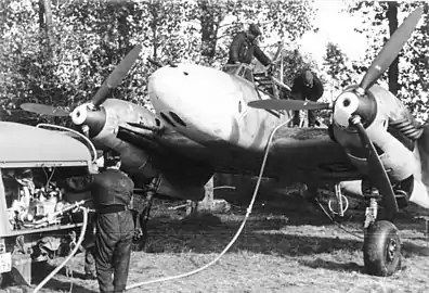 Un Messerschmitt Bf 110 de l'escadrille Horst-Wessel au ravitaillement d'essence (France, octobre 1940, à l'époque de la bataille d'Angleterre, essentiellement aérienne).