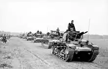 photographie en noir et blanc de tanks en file indienne