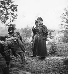 Photographie en noir et blanc de Eicke, vêtu d'un long manteau d'uniforme en Russie en septembre 1941