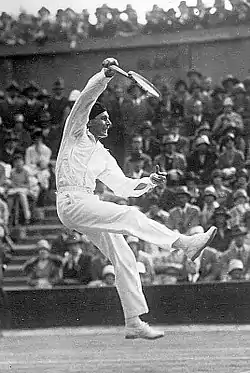 Photographie en noir et blanc d'un joueur de tennis en action.