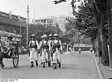 Dans une artère de Bombay en 1932, marins britanniques patrouillant en armes pour assurer l’ordre public.