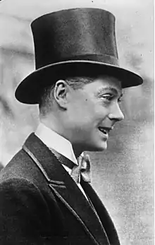 Photographie en noir et blanc d'un jeune homme portant un chapeau haut-de-forme.