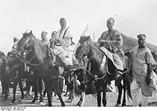 Photographie en noir et blanc de plusieurs cavaliers africains.