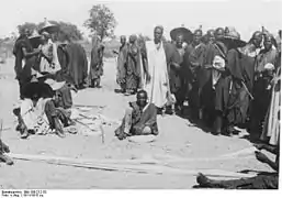 Mesure de bandes de coton tissé au marché de Mora vers 1911-1915.