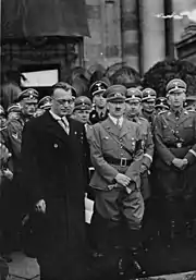 Photographie en noir et blanc de 1938 sur laquelle figurent, de gauche à droite, Arthur Seyss-Inquart, en civil, Adolf Hitler, Heinrich Himmler et Reinhard Heydrich, en uniforme (1938)
