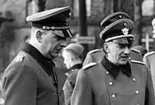 Photographie en noir et blanc de deux hommes en uniforme.